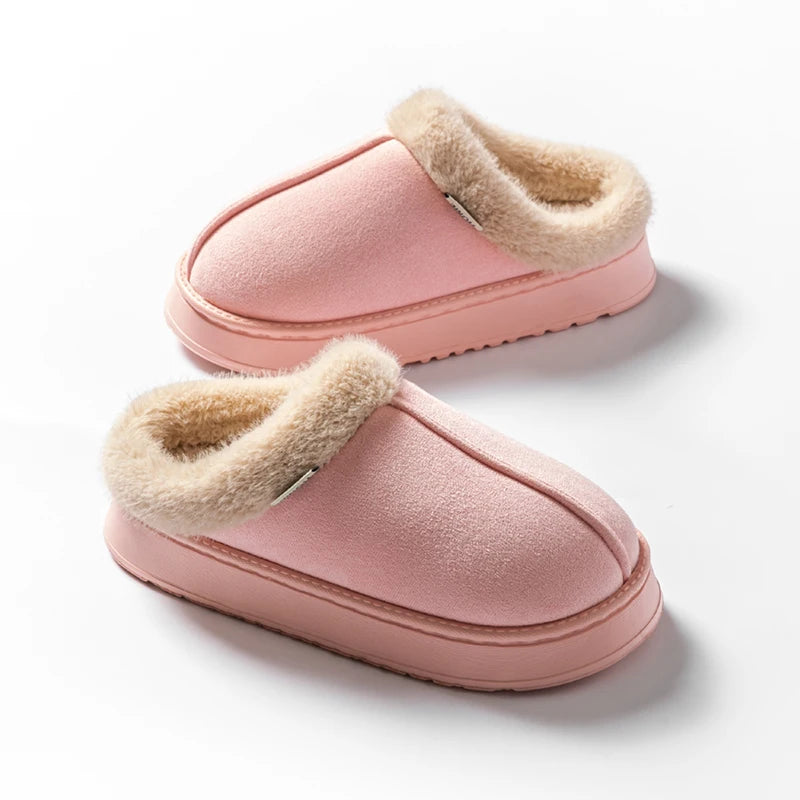Pair of pink slippers with beige fur lining on a white background